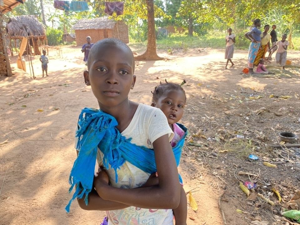 Girl with baby sister on back